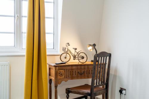 a desk with a bike on it next to a window at Wilkinsons Home-Free parking, Perfect For Contractors & Weekend getaways, Near London City Airport & Excel in London