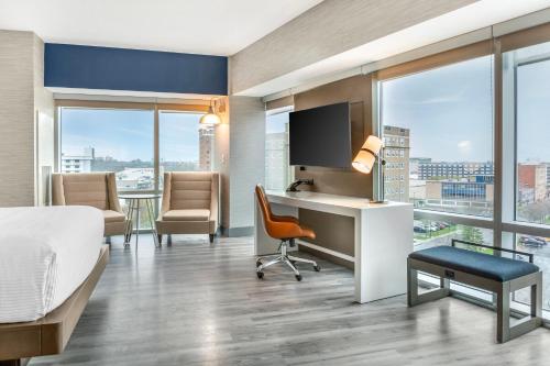 ナイアガラフォールズにあるCambria Hotel Niagara Fallsのベッドと机と椅子があるホテルの部屋