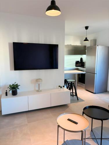 un salon avec une télévision à écran plat sur un mur dans l'établissement Charmant appartement à Ajaccio, proche de la mer !, à Ajaccio