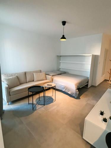 un salon avec un canapé et un lit dans l'établissement Charmant appartement à Ajaccio, proche de la mer !, à Ajaccio