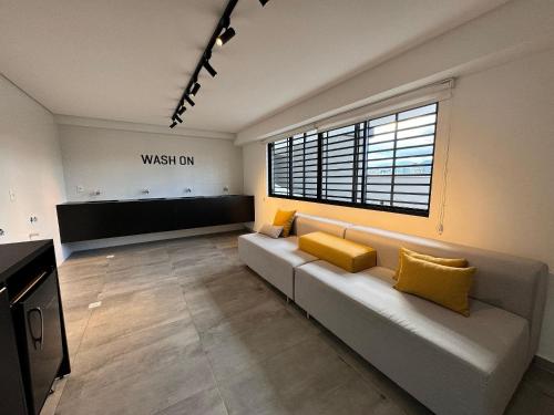 a living room with a couch and a large window at RCM Vilas - Studio H in Joinville