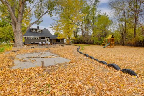 a yard filled with leaves with a house and a playground at 6 Mi to Shoshone Falls Park Home with Game Room! in Twin Falls