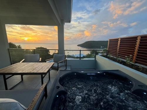 a hot tub on the balcony of a house at CAP KARAIB Grande Villa in Les Anses-dʼArlets