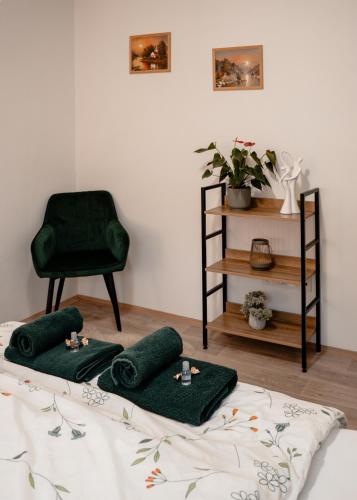 a room with a bed with green pillows and a chair at Pohodička pod Verpánem in Batňovice