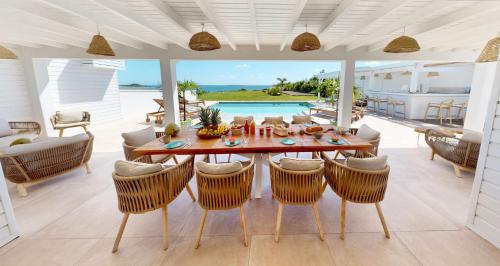 a dining room with a table and chairs at SUNSEEKER SXM - Luxury Guest House 4 stars - Amazing Sea View Pinel - Tintamarre in Orient Bay