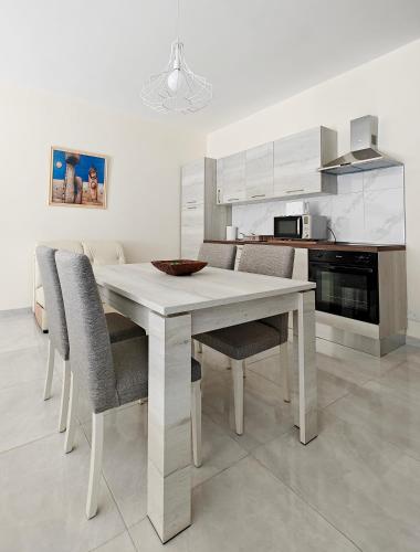 a white dining room table and chairs in a kitchen at Seaside 3 in Marsaskala