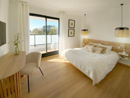 a bedroom with a bed and a desk and a window at L'Escapade vintage in Eschau