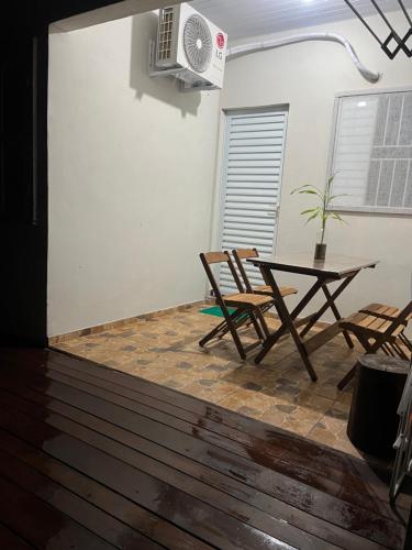 a room with a table and chairs and a fan at Pousada Rural João De Barro in Capela Ivapurunduva
