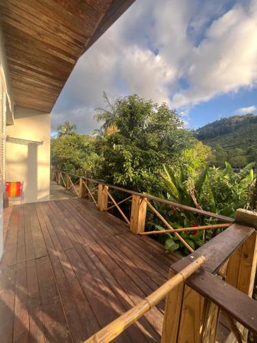 a wooden deck with a view of the mountains at Pousada Rural João De Barro in Capela Ivapurunduva