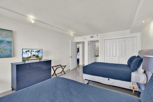 a bedroom with a bed and a dresser with a tv at Bahia Mar-Solare Tower, Beachfront Resort with Two Pools in South Padre Island