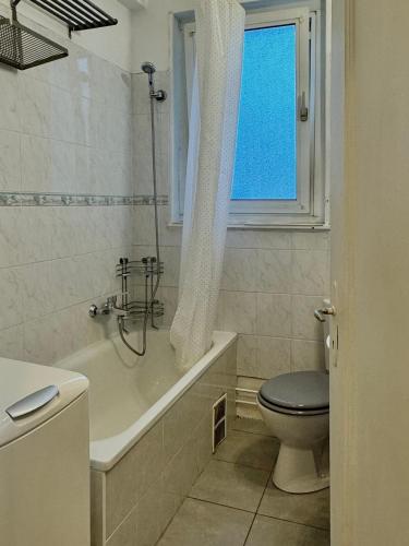 La salle de bains est pourvue de toilettes, d'une baignoire et d'une fenêtre. dans l'établissement Hyper Centre Krutenau Étoile Bourse Appart, à Strasbourg