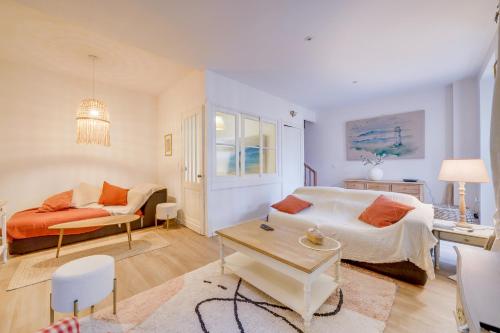 a bedroom with a bed and a couch and a table at Entre Vignes et Roses Wifi-Terrasse in Saint-Estèphe