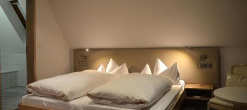 a bed with white pillows on it in a room at Castell Hotel & Restaurant in Leinsweiler