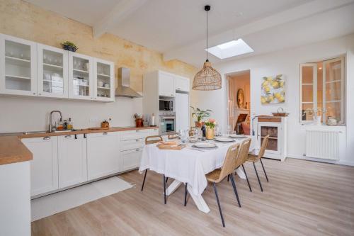une cuisine avec une table et des chaises dans une pièce dans l'établissement Entre Vignes et Roses Wifi-Terrasse, à Saint-Estèphe