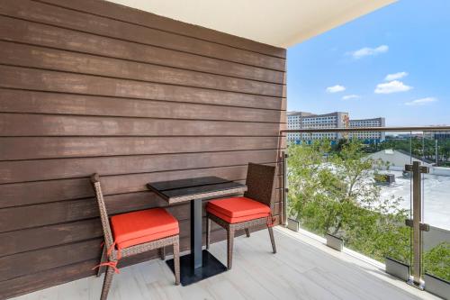a table and two chairs on a balcony with a view at Cambria Hotel Orlando near Universal Theme Parks in Orlando