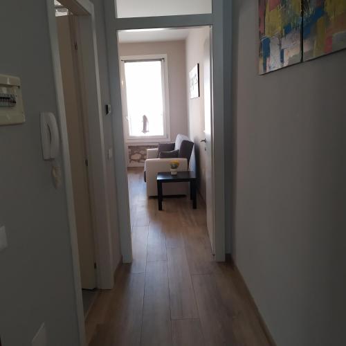 a hallway with a living room with a chair and a window at Appartamento Lonigo centro in Lonigo