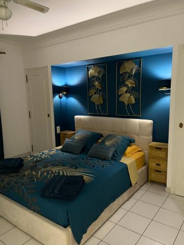 a bedroom with a large bed with blue walls at Bel appartement à Perpignan in Perpignan