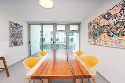 a dining room with a wooden table and yellow chairs at Luxury suite at Solemare suite with pool and wifi in San Juan