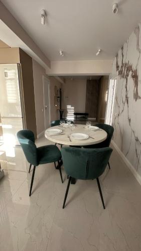 a dining room with a table and green chairs at Apartments in center of Chisinau Anestiade in Chişinău