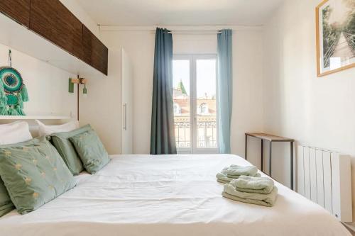une chambre avec un lit blanc avec des serviettes dessus dans l'établissement Homelivia Av Jean Médecin, à Nice