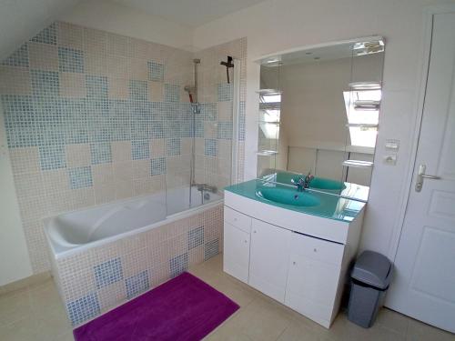 Un baño con bañera, lavabo y espejo. en Gîte du Buron 6 8 personnes, en Longueville