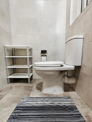 a bathroom with a toilet and a rug at Seaside 4 in Marsaskala