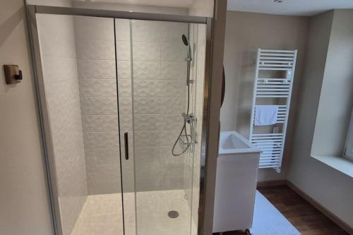 une douche avec une porte vitrée dans une salle de bain dans l'établissement Chez Maude et Clément, à Mer