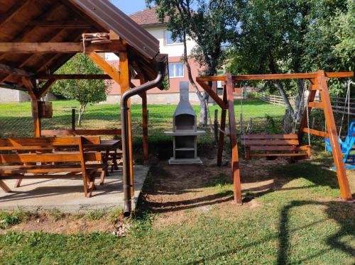 een speeltuin met bankjes en een bel in een park bij Apartmani Šarac - Pale in Pale