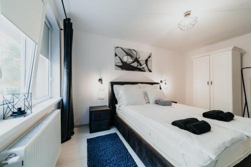 Un dormitorio blanco con una cama grande y una ventana. en Fanni Apartment, en Odorheiu Secuiesc