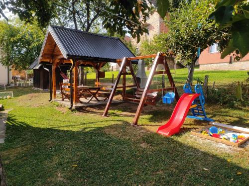 een speeltuin met een schommel en een tafel bij Apartmani Šarac - Pale in Pale