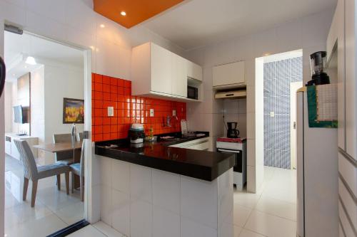 a kitchen with a counter and a table in it at Apto com ar-condicionado a 350m do mar em Aracaju in Santa Maria