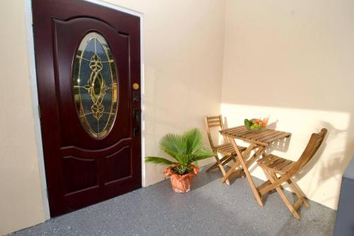 a room with a door and a table and chairs at Taylor's Retreat - 5min to Sandals Resort & Beach in Buccament