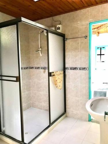a shower with a glass door in a bathroom at Casa en las Nubes, Melgar Tolima in Melgar