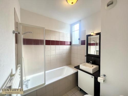 une salle de bain avec une baignoire et un lavabo dans l'établissement Chez Laure et Guilhem, à Luchon