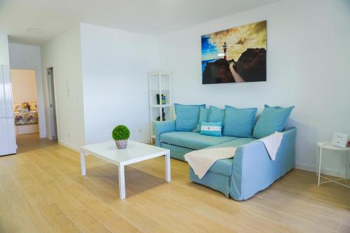 a living room with a blue couch and a table at Apartamento frente al mar in Puertito de Güímar
