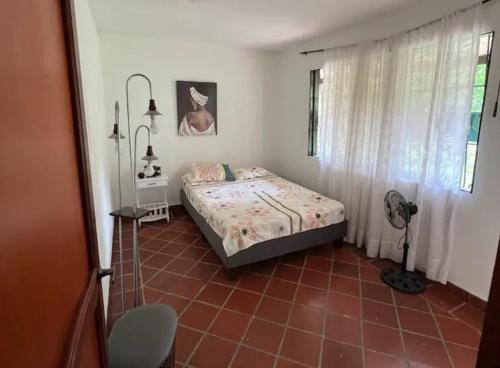 a bedroom with a bed and a red tile floor at Casa Campestre El Silencio con Familias Exitosas in Rivera