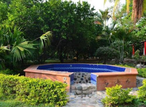 a swimming pool in a yard with trees and bushes at Casa Campestre El Silencio con Familias Exitosas in Rivera