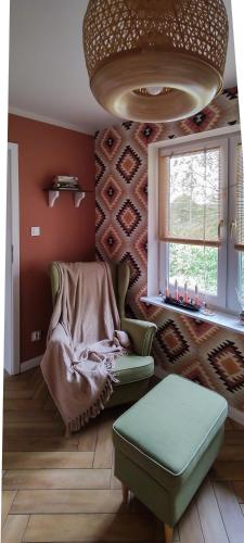 a living room with a chair and a window at Domek z ogrzewaniem podłogowym in Wyszki