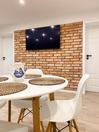 a dining room with a white table and chairs at Domek z ogrzewaniem podłogowym in Wyszki
