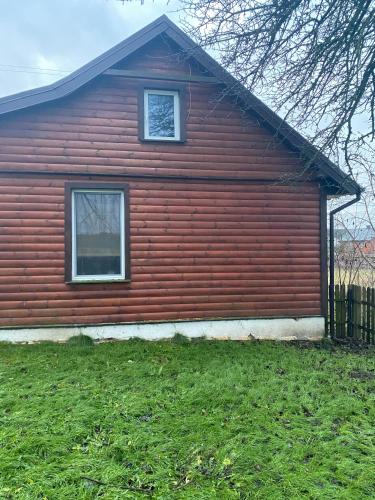 a red house with a window on the side of it at Domek z ogrzewaniem podłogowym in Wyszki