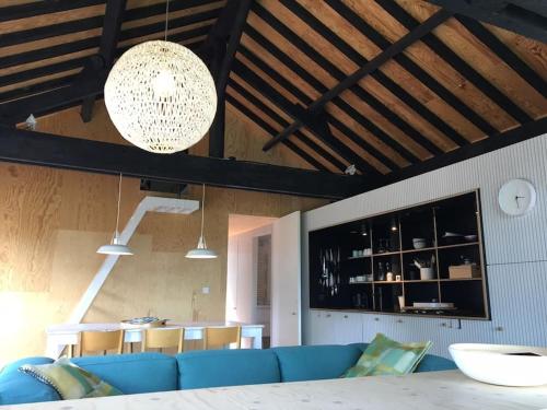 a living room with a blue couch and a table at Super view Am Flachsberg in Butgenbach