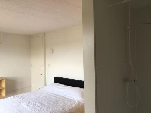 a bedroom with a white bed and a glass wall at Super view Am Flachsberg in Butgenbach
