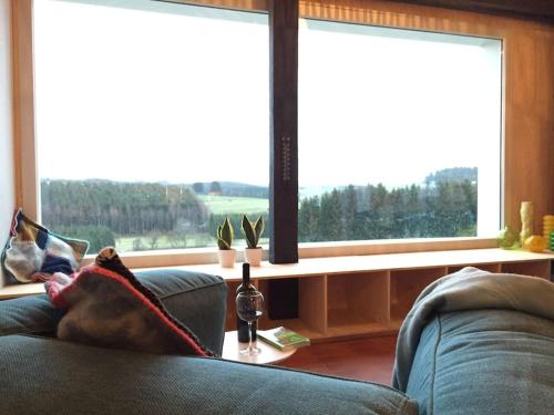 a living room with a couch and a large window at Super view Am Flachsberg in Butgenbach