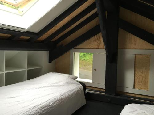a bedroom with a white bed and a window at Super view Am Flachsberg in Butgenbach