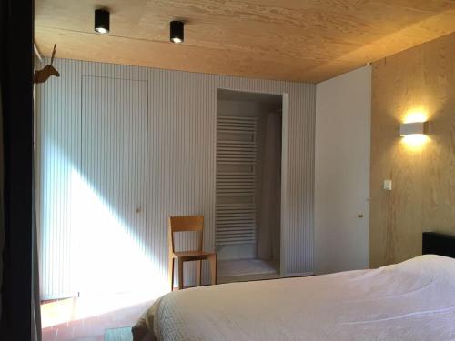 a bedroom with a bed and a chair and a window at Super view Am Flachsberg in Butgenbach