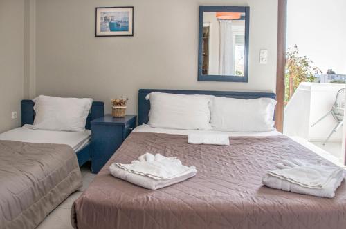a bedroom with two beds with towels on them at Christina Rooms in Adamas