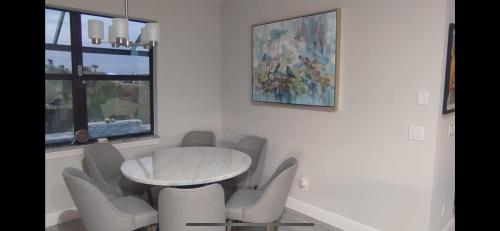 a white dining room with a table and chairs at Newly built Villa Ballerina with heated pool and incredible view into beautiful Arrowheadcanal in Cape Coral