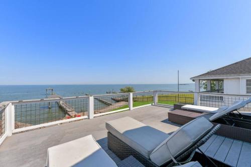 a deck with chairs and a view of the ocean at Bayfront Luxury House with Pool in Kemah