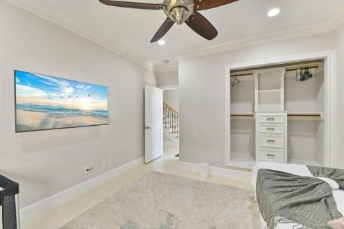 a living room with a ceiling fan and a couch at Bayfront Luxury House with Pool in Kemah