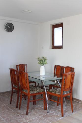 a dining room table with chairs and a vase with flowers at Salaš Belo Brdo in Čerević